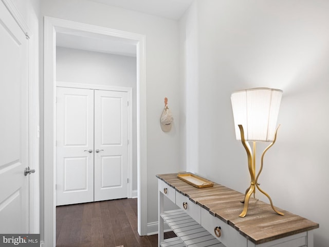 hall featuring baseboards and dark wood-style flooring