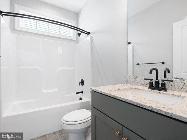 full bath featuring toilet, shower / bathtub combination, wood finished floors, and vanity