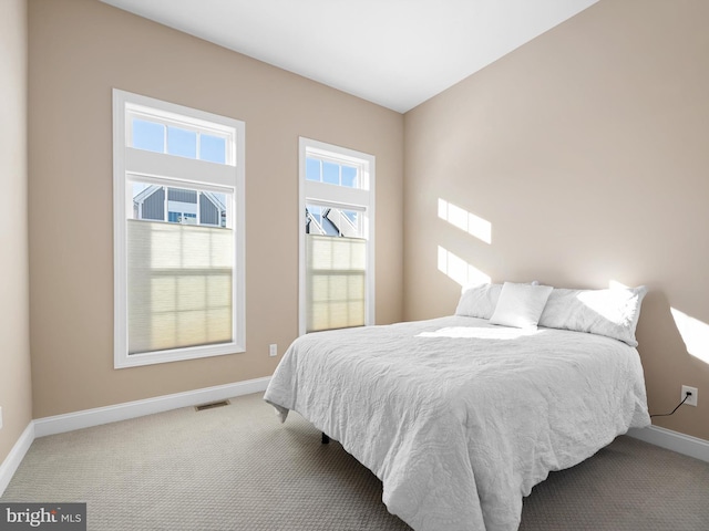 bedroom featuring light colored carpet, visible vents, and baseboards