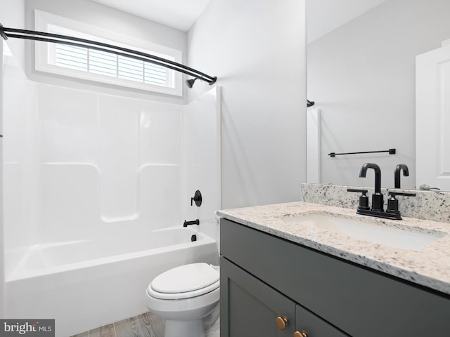 bathroom featuring bathtub / shower combination, vanity, toilet, and wood finished floors