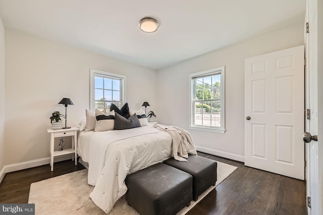 bedroom with dark wood-type flooring and multiple windows