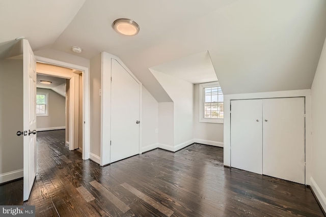 additional living space featuring dark hardwood / wood-style flooring and lofted ceiling