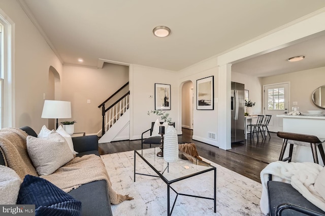 living room featuring dark hardwood / wood-style flooring and crown molding