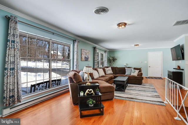 living room featuring hardwood / wood-style flooring, baseboard heating, and crown molding