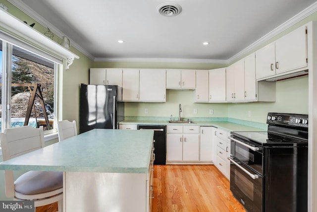 kitchen with white cabinetry, ornamental molding, black appliances, light hardwood / wood-style flooring, and sink