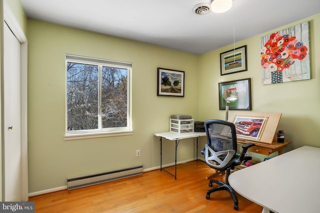 office space featuring a baseboard radiator and light wood-type flooring