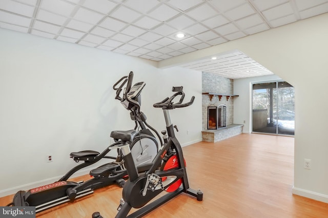 workout room featuring a large fireplace and light hardwood / wood-style flooring