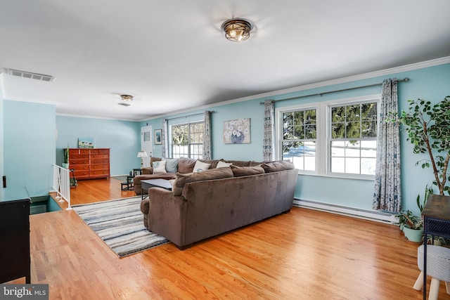 living room with light wood-type flooring, ornamental molding, and a baseboard radiator