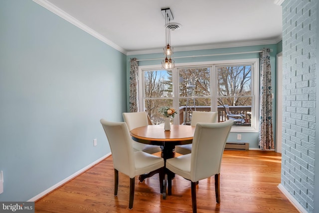 dining space featuring crown molding, a baseboard radiator, and light hardwood / wood-style flooring