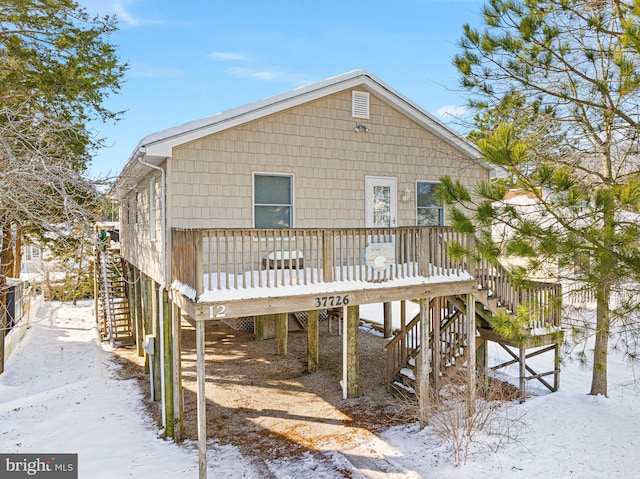 snow covered property with a deck