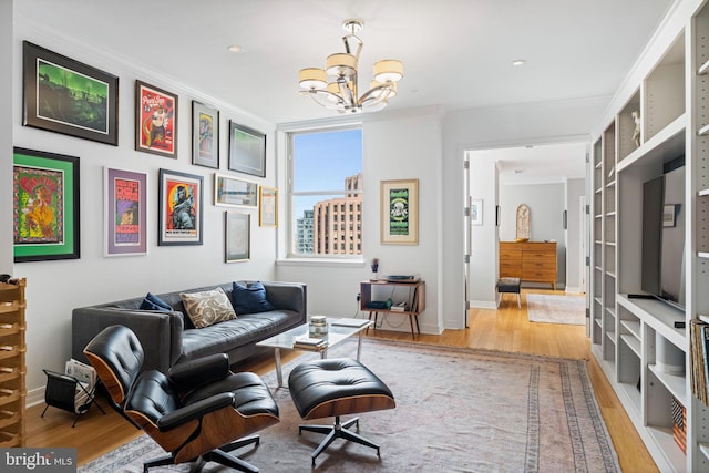 living room featuring ornamental molding, an inviting chandelier, and light hardwood / wood-style flooring