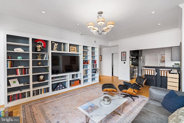 living room with ornamental molding, a chandelier, and light wood-type flooring