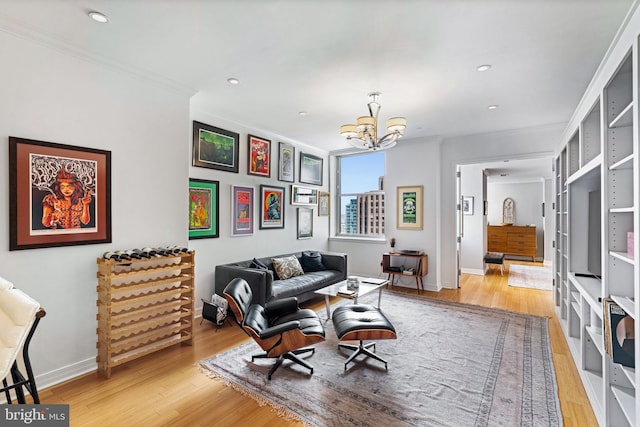 living area with crown molding, a notable chandelier, and light wood-type flooring