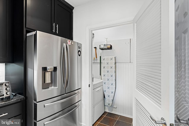 kitchen featuring dark tile patterned floors and stainless steel refrigerator with ice dispenser