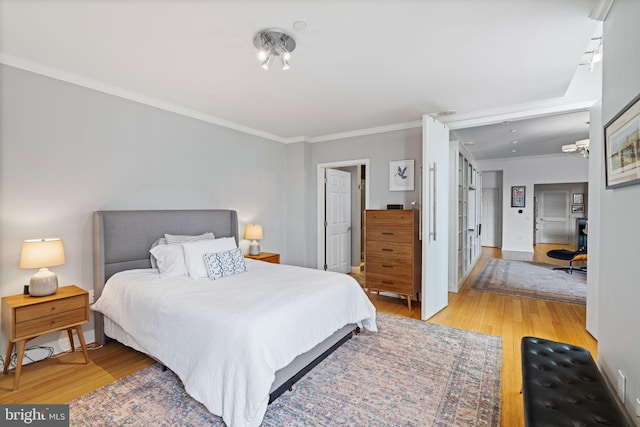 bedroom featuring ornamental molding and light hardwood / wood-style floors