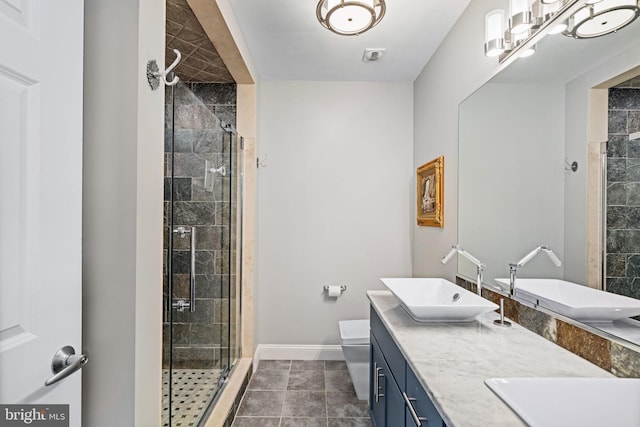 bathroom featuring tile patterned flooring, vanity, toilet, and a shower with shower door