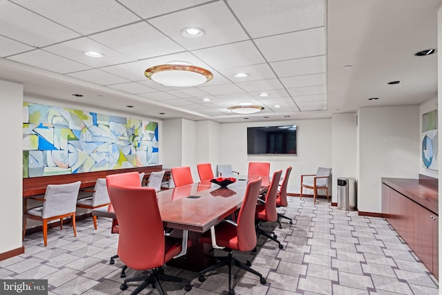 carpeted dining space with a drop ceiling