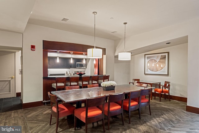 dining area featuring dark parquet floors