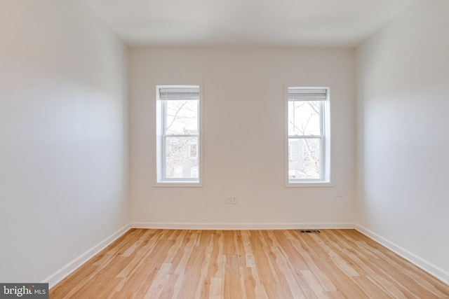 spare room featuring light hardwood / wood-style flooring and plenty of natural light