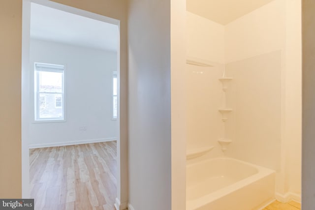 bathroom with hardwood / wood-style flooring and tub / shower combination