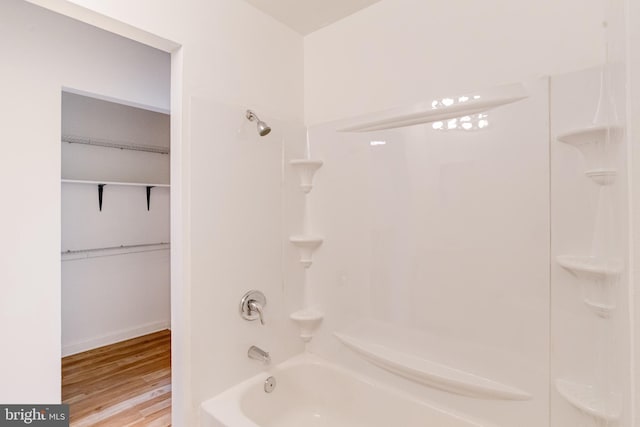 bathroom with bathing tub / shower combination and hardwood / wood-style floors