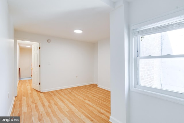 spare room with wood-type flooring and a healthy amount of sunlight