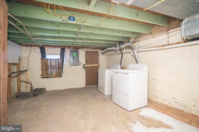 basement featuring electric panel and washing machine and clothes dryer