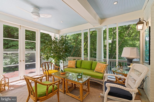 sunroom / solarium with ceiling fan, a healthy amount of sunlight, and beamed ceiling