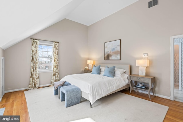 bedroom with wood-type flooring and vaulted ceiling