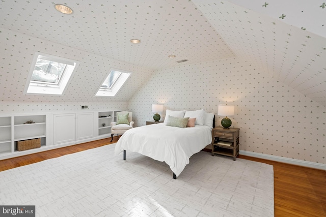 bedroom with light wood-type flooring and vaulted ceiling with skylight