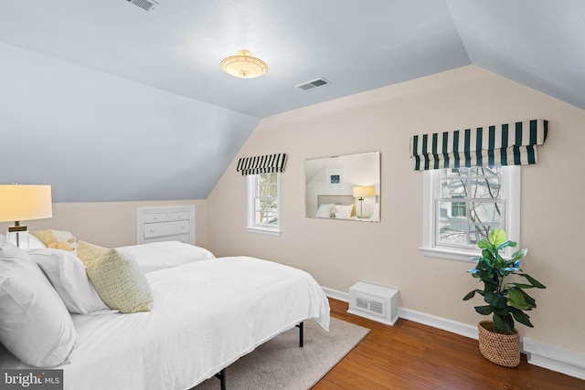 bedroom with lofted ceiling, multiple windows, and dark hardwood / wood-style floors