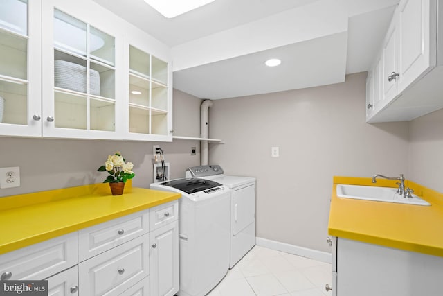 laundry area with washer and dryer, cabinets, light tile patterned floors, and sink