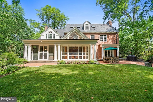 back of property with a patio, french doors, and a yard