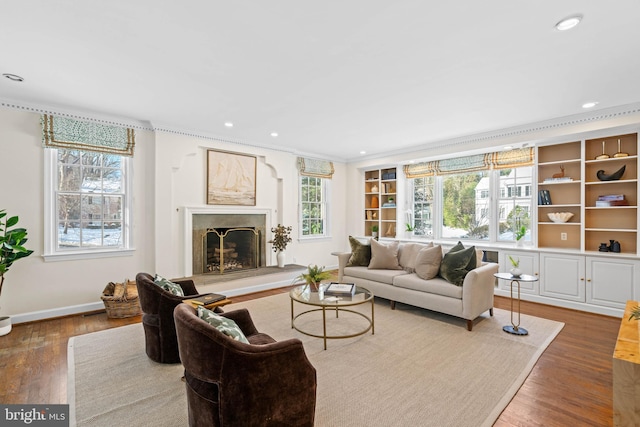 living room with ornamental molding, a high end fireplace, and hardwood / wood-style flooring