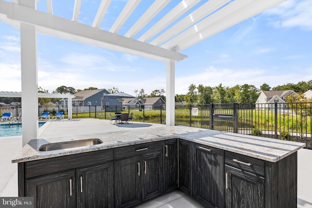 view of patio / terrace with exterior bar, a pergola, and a community pool