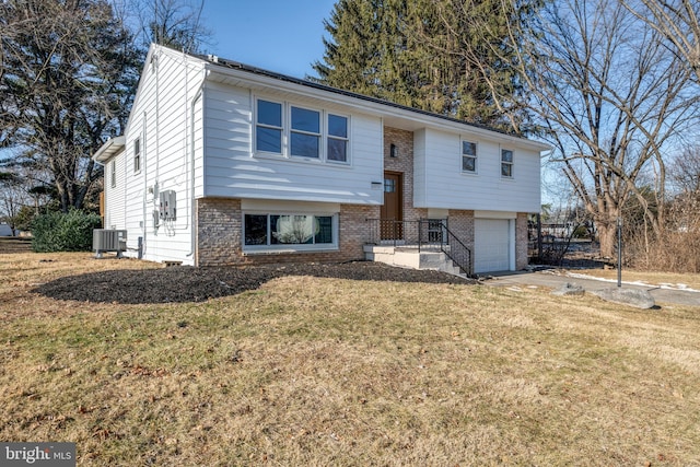 bi-level home featuring cooling unit, a garage, and a front yard