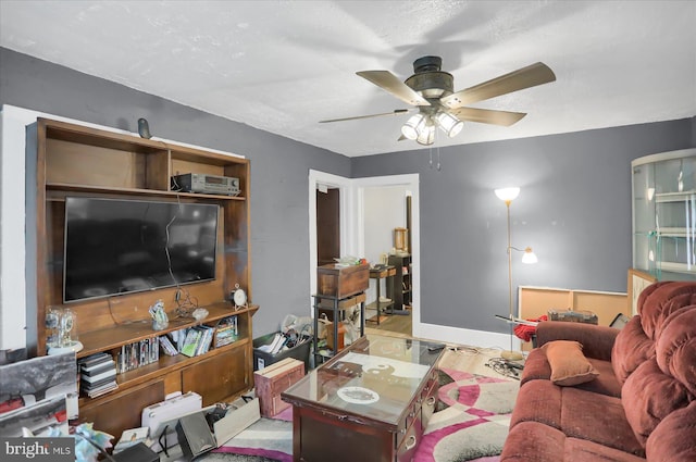 living room with ceiling fan and a textured ceiling