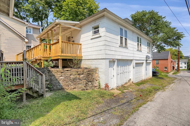 view of side of home with a garage and a deck