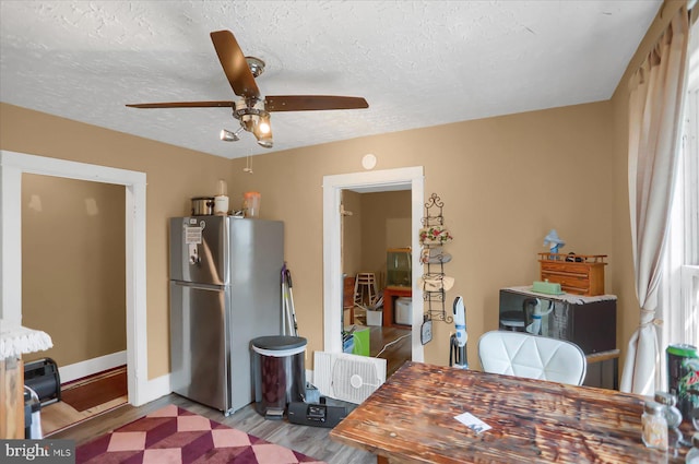 dining room with a textured ceiling, ceiling fan, and light hardwood / wood-style floors