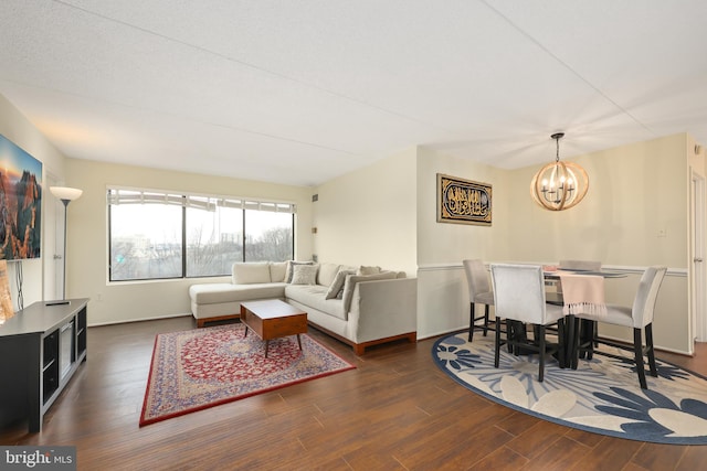 living room featuring dark hardwood / wood-style flooring and an inviting chandelier