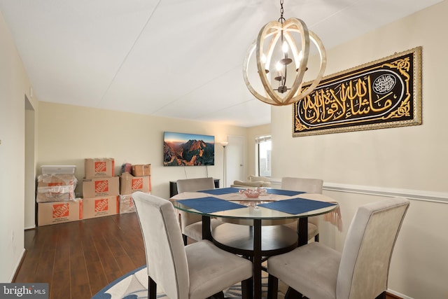 dining space featuring dark wood-type flooring and a chandelier