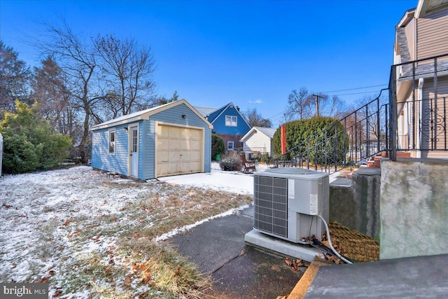 exterior space featuring central AC unit, a garage, and an outbuilding