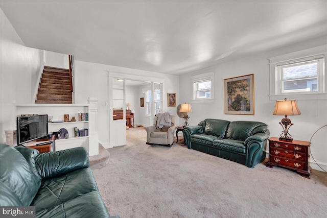 living room featuring carpet floors and stairway