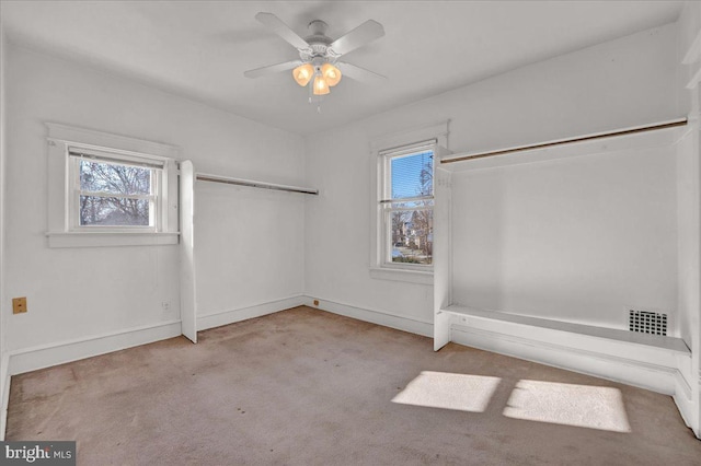 carpeted spare room featuring ceiling fan