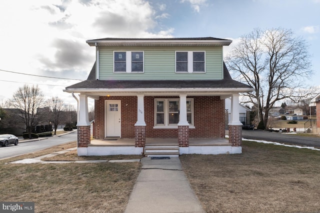 view of front of house with a front yard and a porch