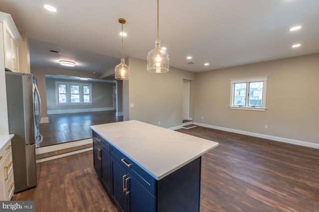 kitchen featuring blue cabinets, white cabinets, a center island, stainless steel fridge, and dark wood-type flooring