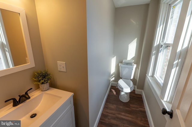 bathroom featuring hardwood / wood-style flooring, a wealth of natural light, vanity, and toilet