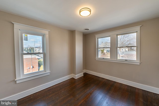 unfurnished room with a healthy amount of sunlight and dark hardwood / wood-style floors