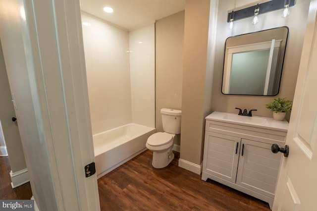 full bathroom with toilet, wood-type flooring, vanity, and  shower combination