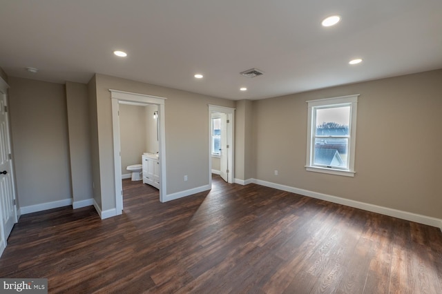 unfurnished bedroom with dark hardwood / wood-style flooring and connected bathroom